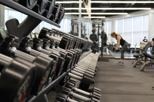 Woman in gym surrounded by exercise equipment for GLP-1 muscle preservation